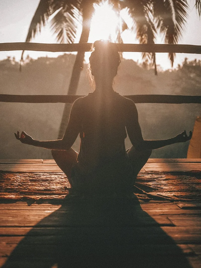 Persona practicando yoga al amanecer en un espacio tranquilo